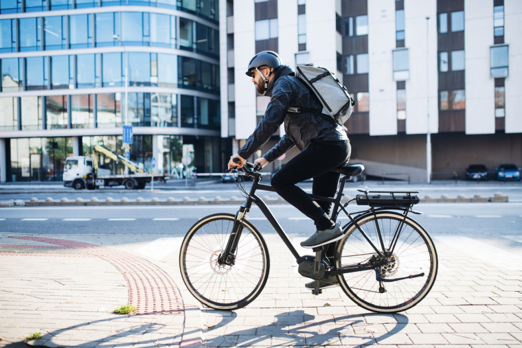 Een fietskoerier bezorgt duurzaam pakketjes in de stad